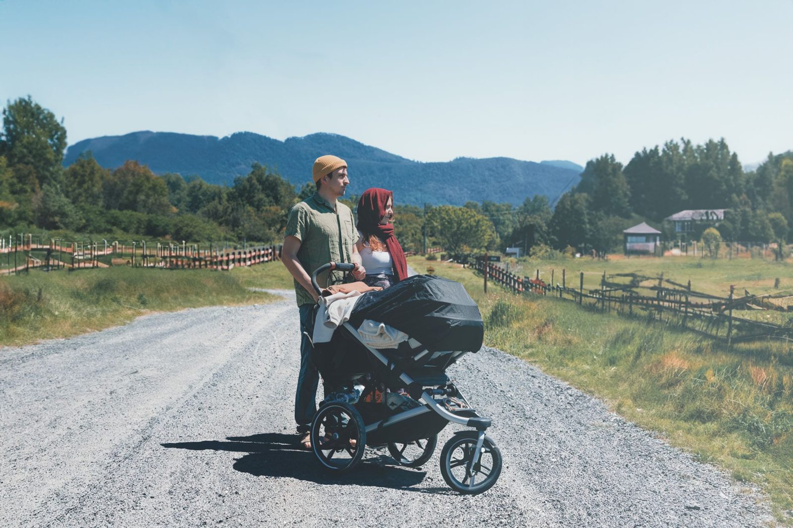 Parents with an all-terrain pushchair on a country road