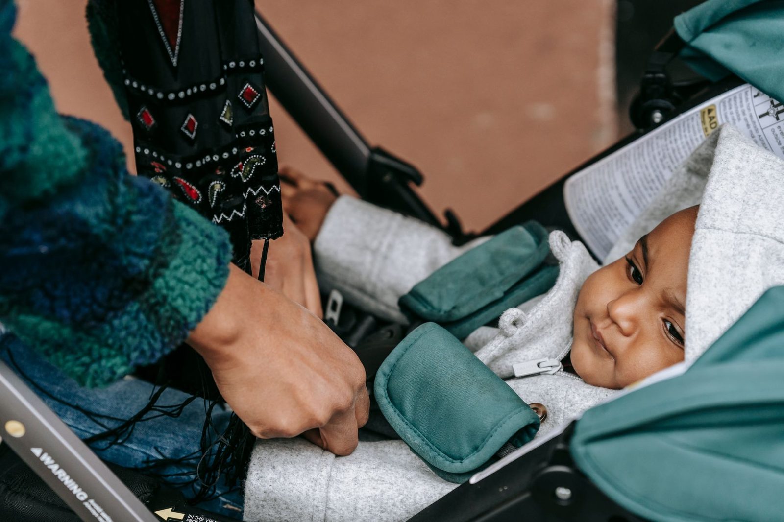 Hands adjusting a pram's fabric